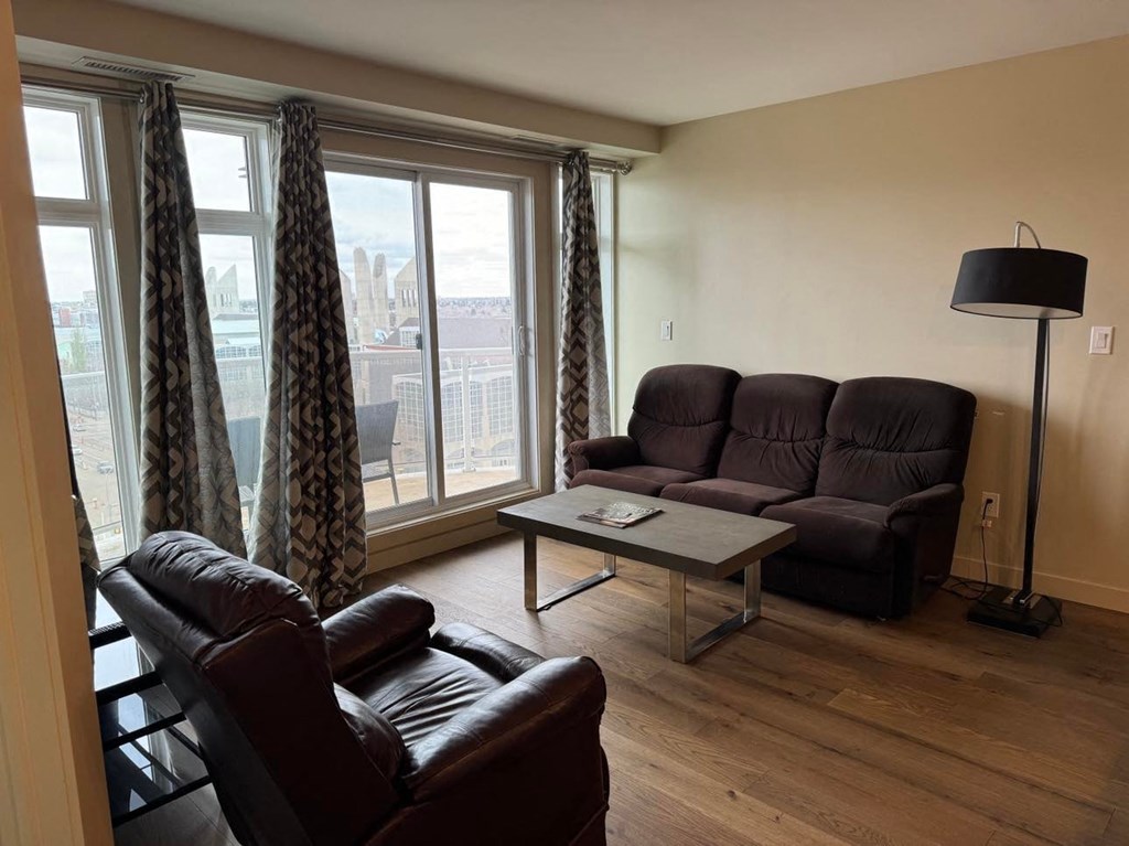 a living room with leather furniture and a large window