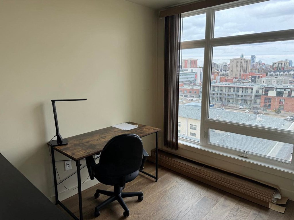 a desk with a chair and a lamp in front of a window