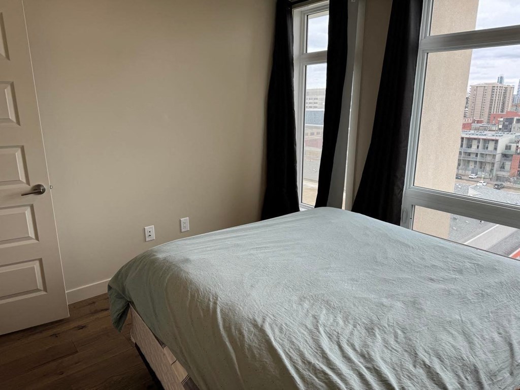 a bedroom with a bed and two windows