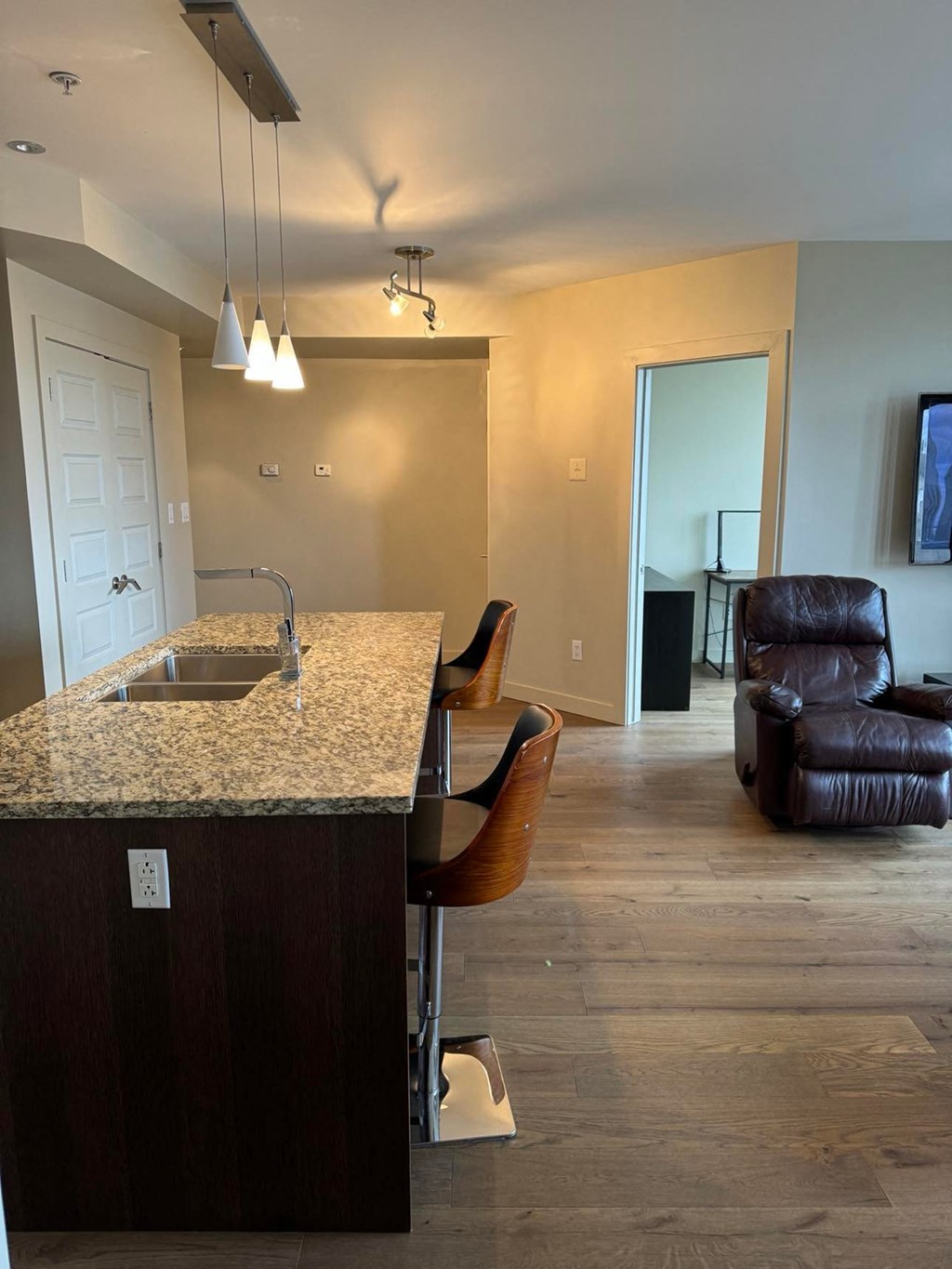 a kitchen with a counter and a living room with a couch