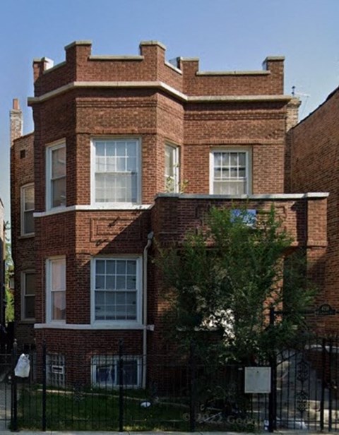 a red brick house with a tree in front of it