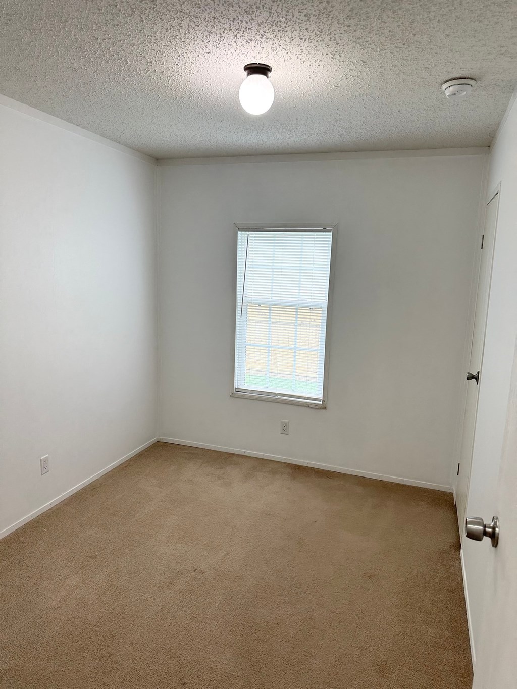 an empty room with a window and a door