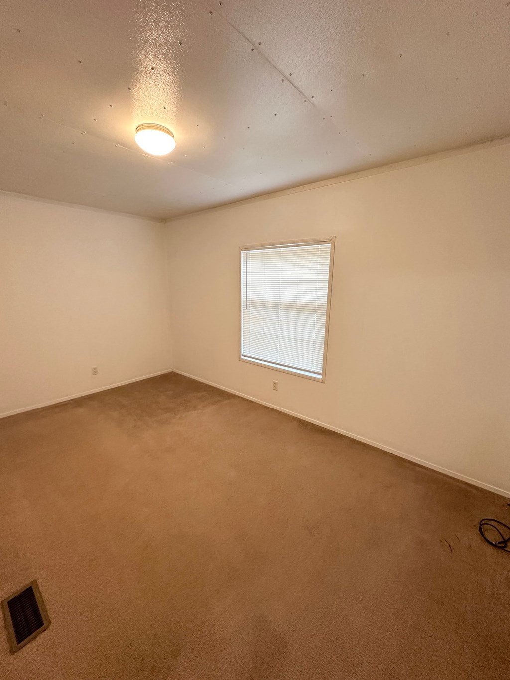 the living room of an empty house with a window