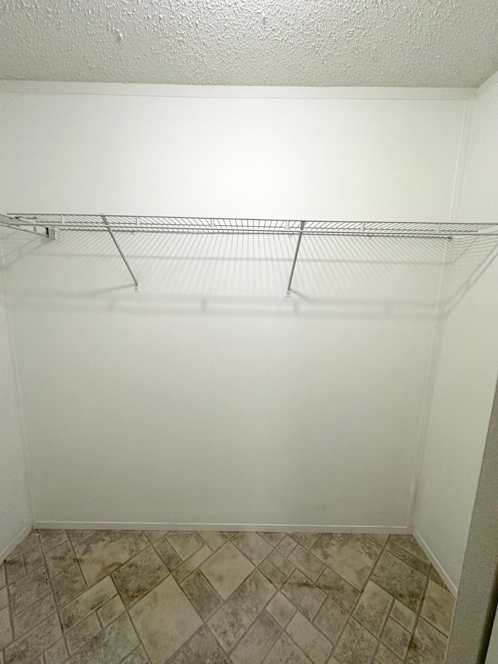 an empty closet in a bathroom with shelves on the wall
