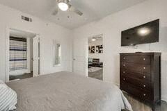 a white bedroom with a large bed and a tv