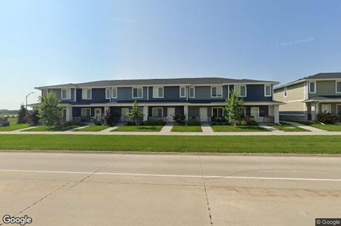 A street view of a row of houses with a clear blue sky above.