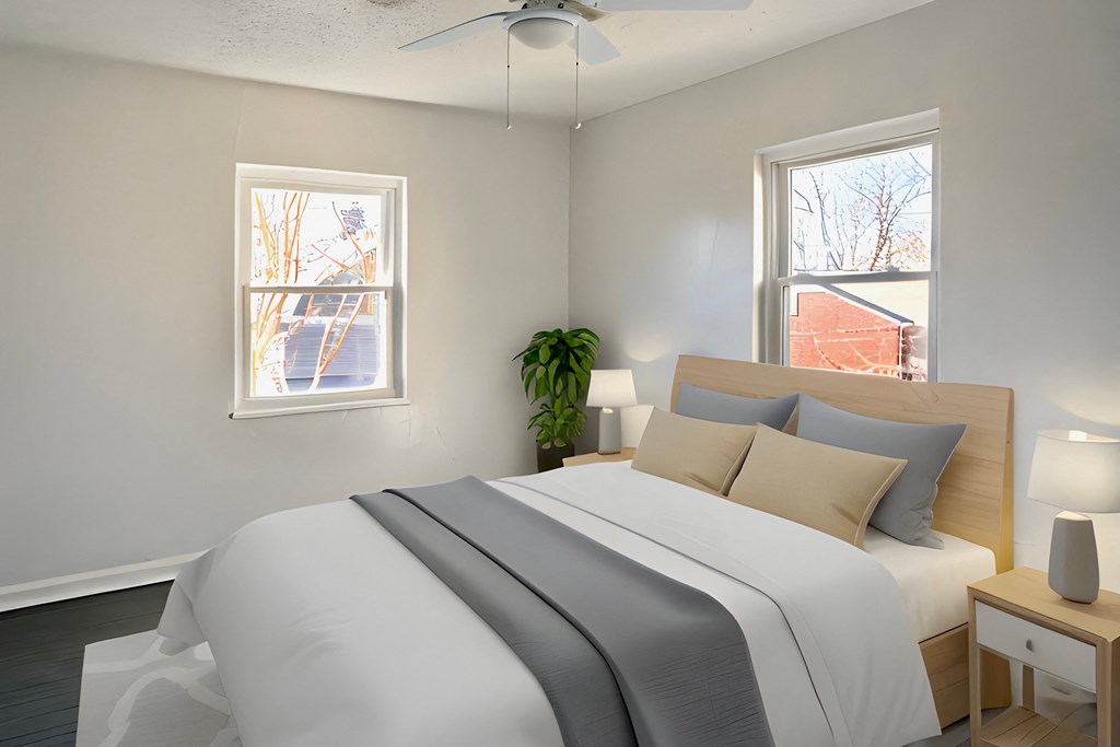 a bedroom with a bed and two windows