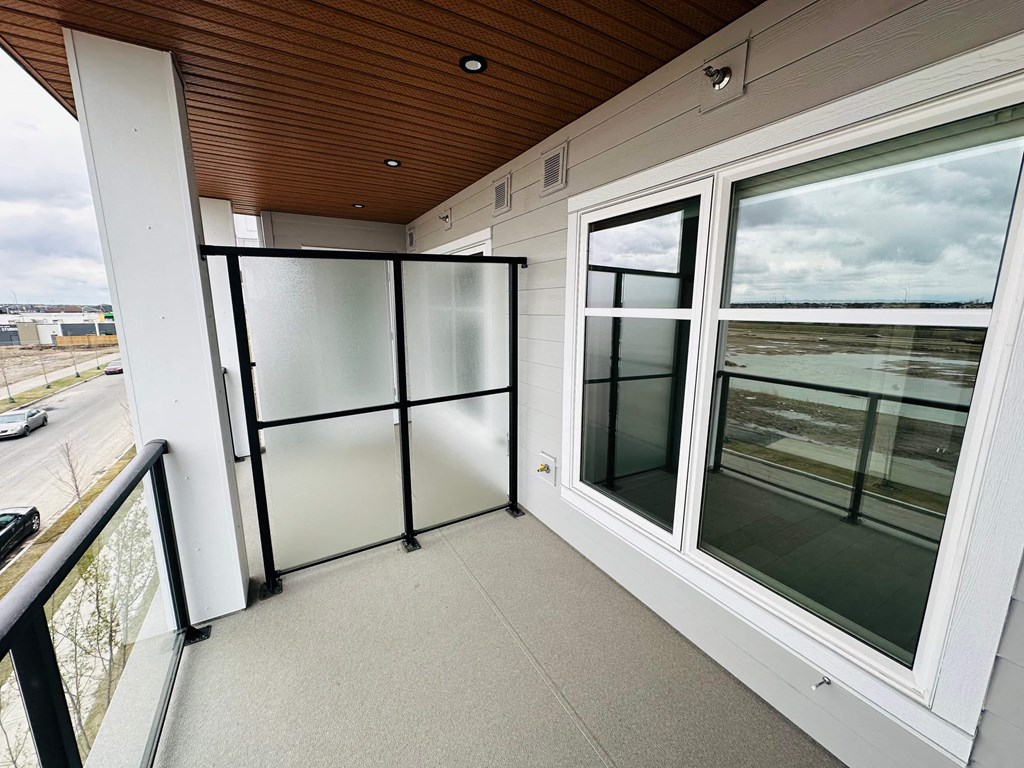 a large balcony with glass doors and a view of an airport