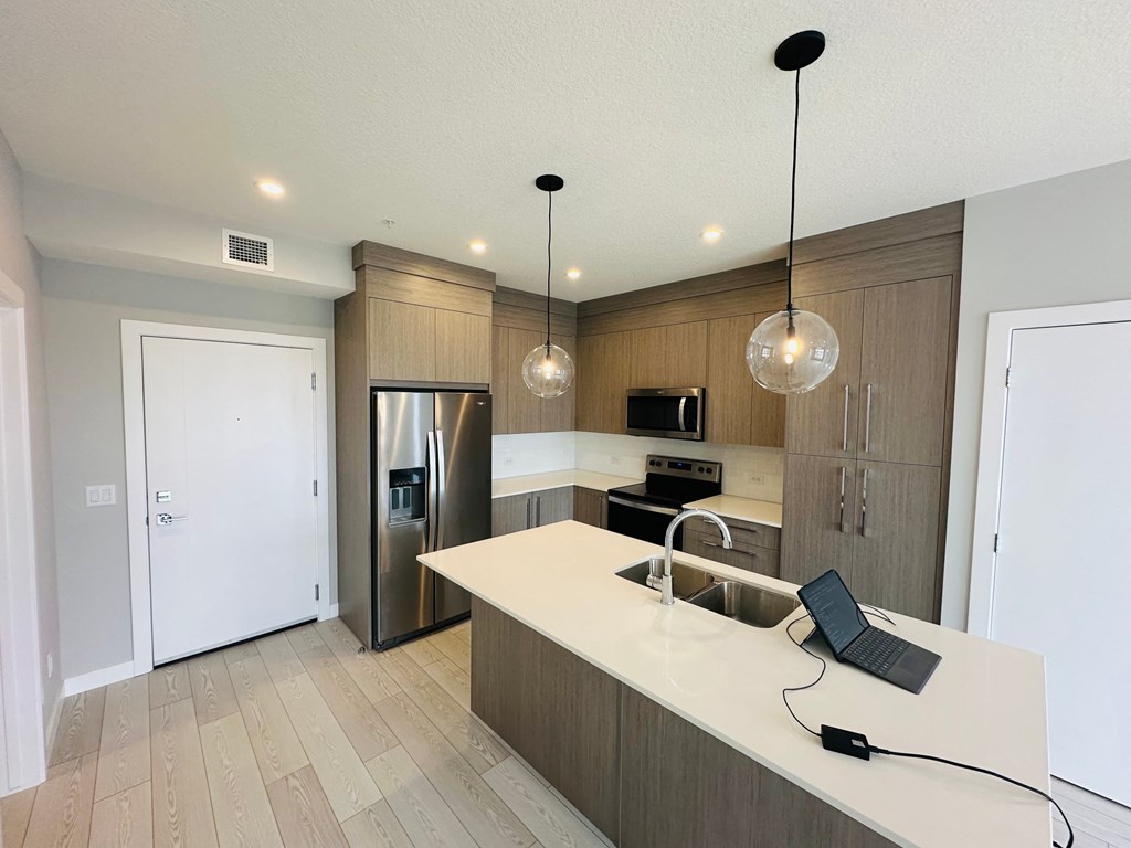 a kitchen with wooden cabinets and a laptop on the counter