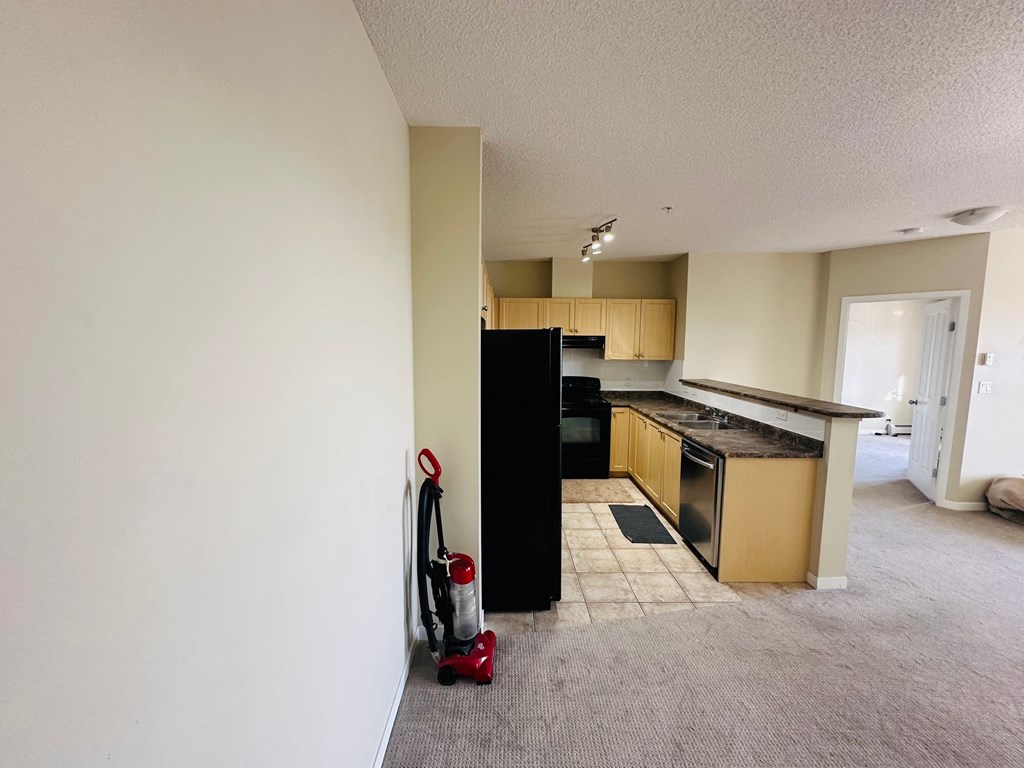 an empty kitchen with a stove and a refrigerator