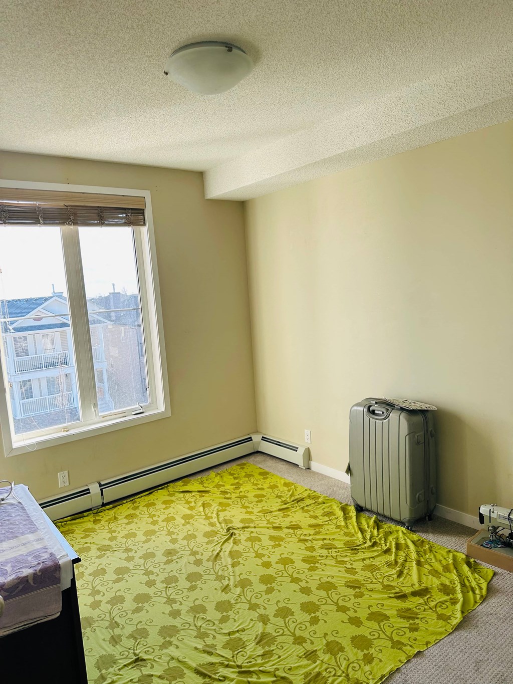 a bedroom with a suitcase on the floor and a window