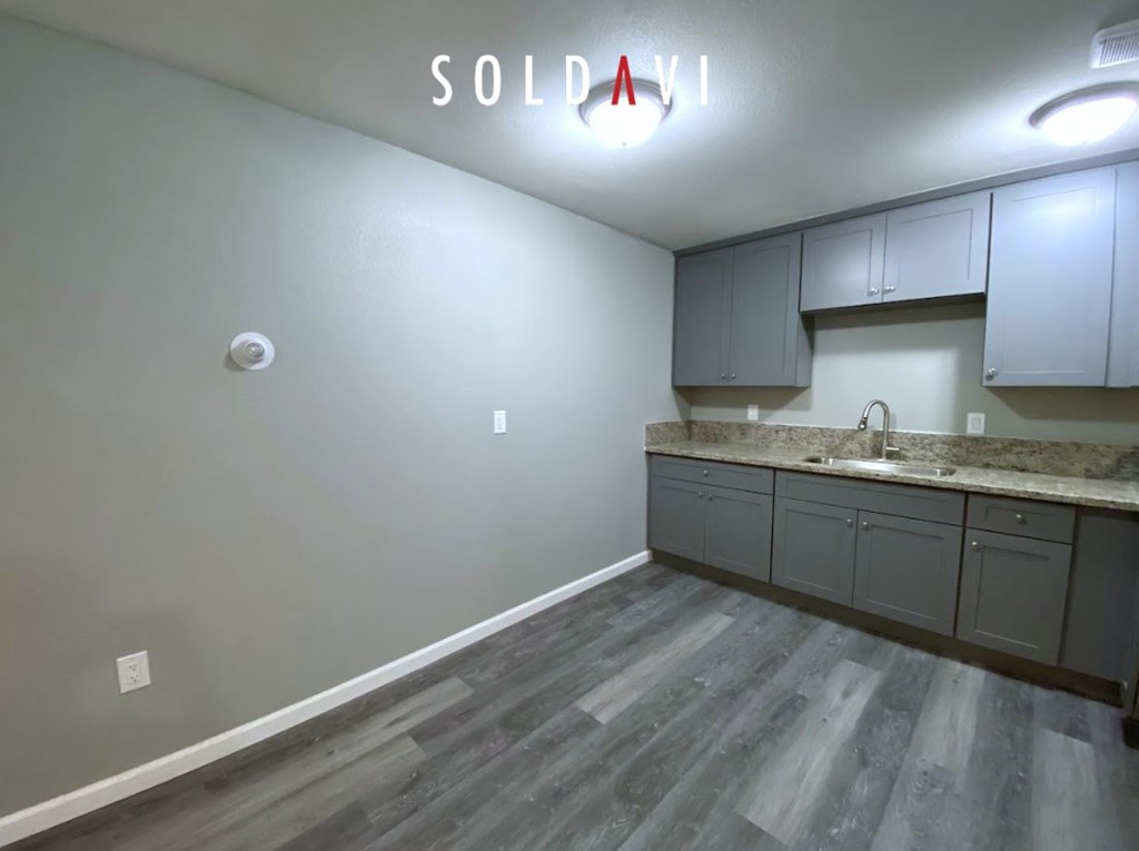 A room with a grey floor and a white wall with a sign that says "SOLD VI".