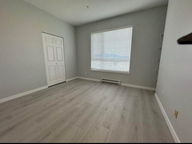an empty room with wooden floors and a window