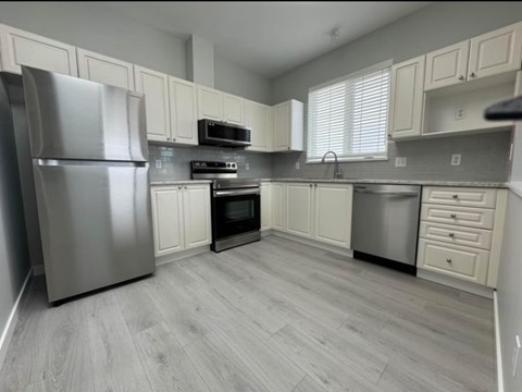 a kitchen with stainless steel appliances and white cabinets