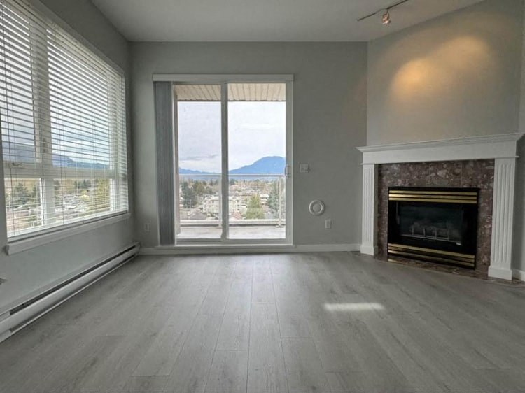 an empty living room with a fireplace and a window