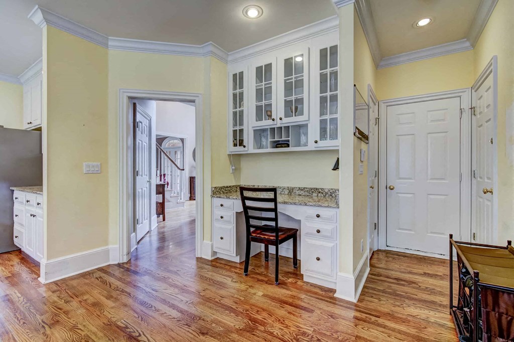 a kitchen with white cabinets and a wooden floor