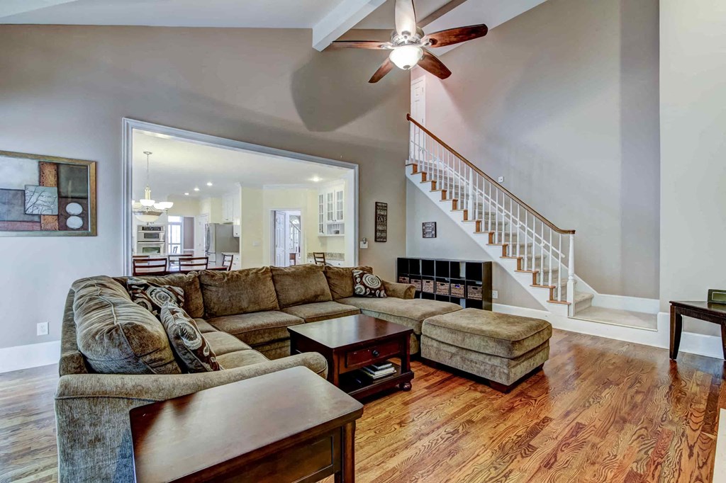 a living room with two couches and a table and a staircase
