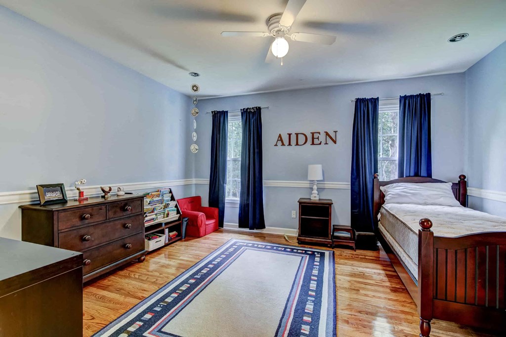 a bedroom with a bed and a dresser and a ceiling fan