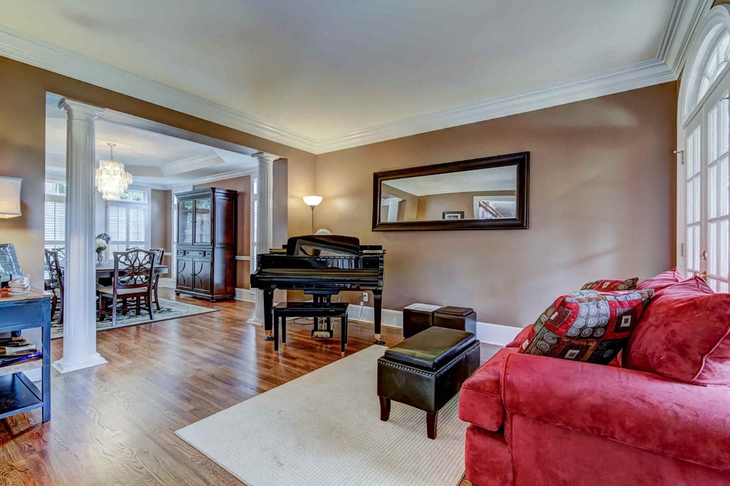 a living room with a red couch and a piano