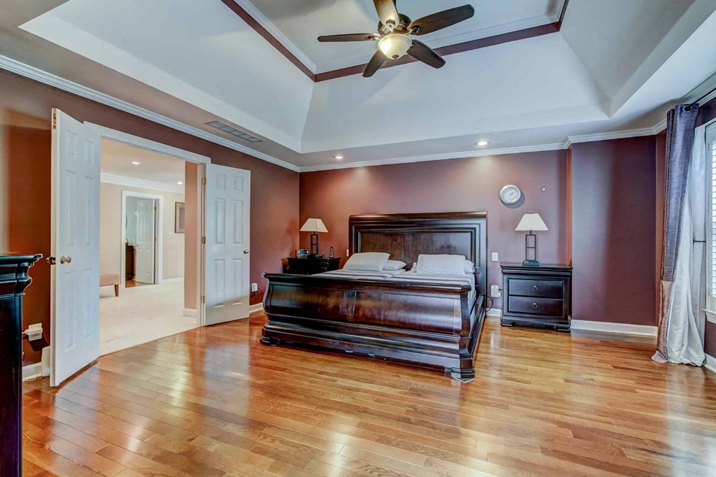 a bedroom with a large bed and a ceiling fan