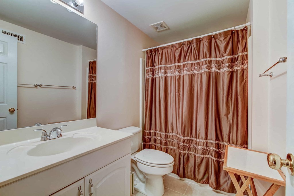 a bathroom with a shower and a toilet and a sink