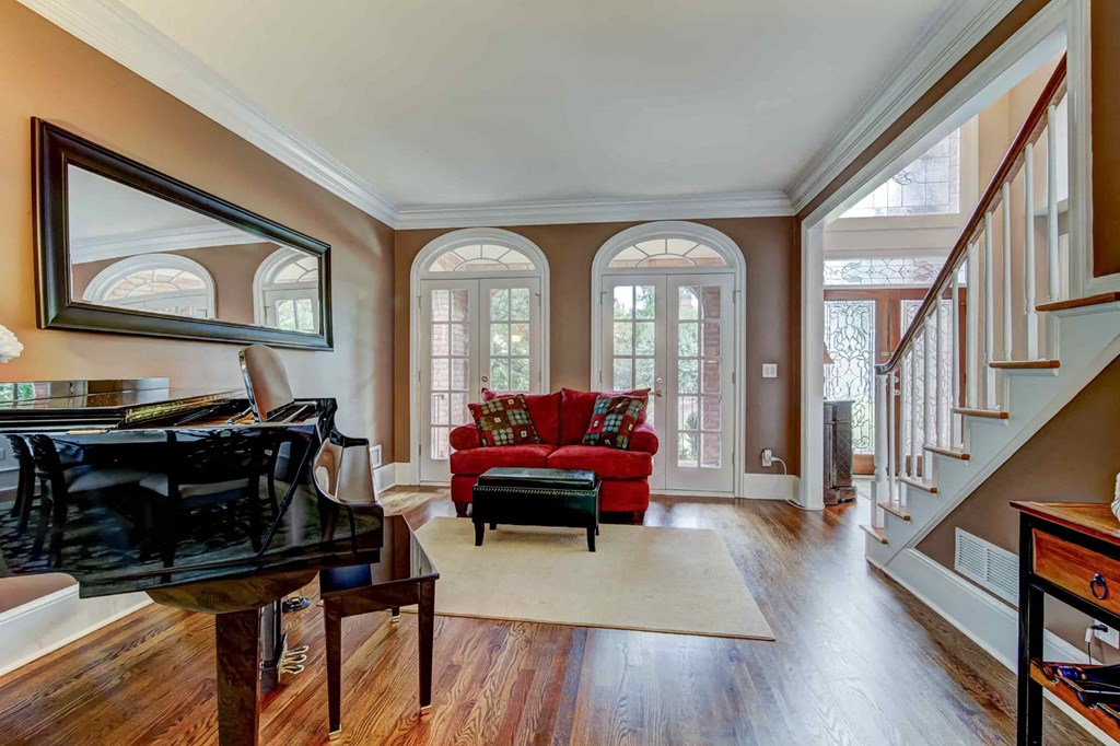 a living room with a red couch and a piano