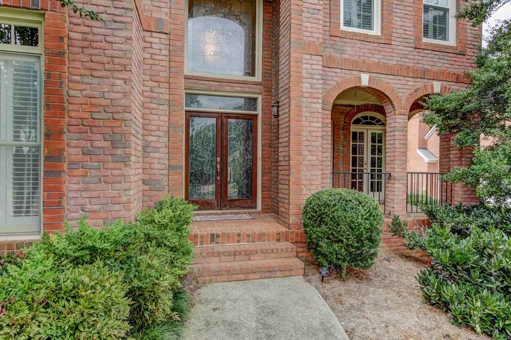 the front of a brick house with a walkway and a front door