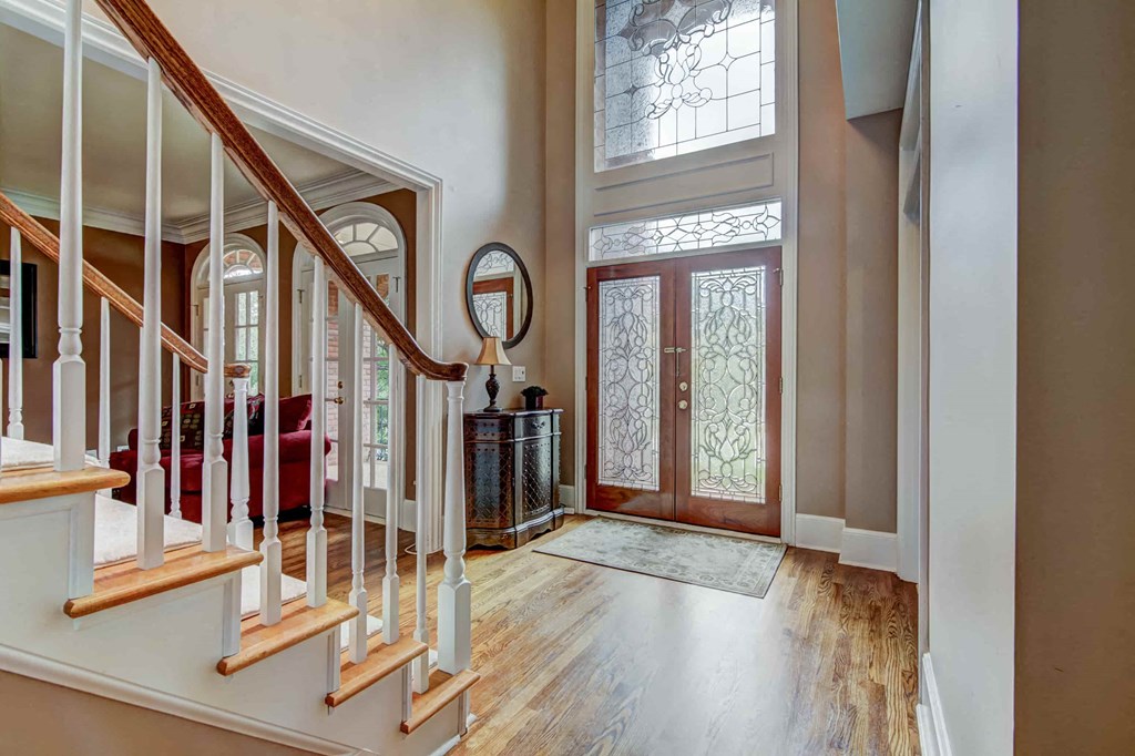 the entryway of a house with a staircase and a glass front door