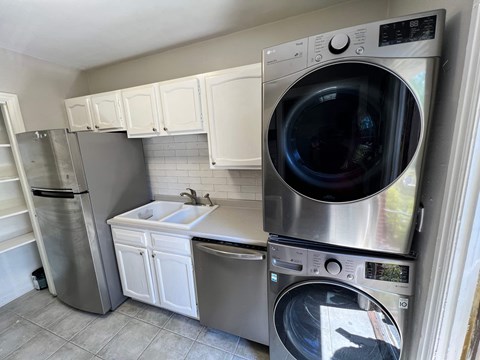 A washing machine is on top of a dryer in a laundry room.