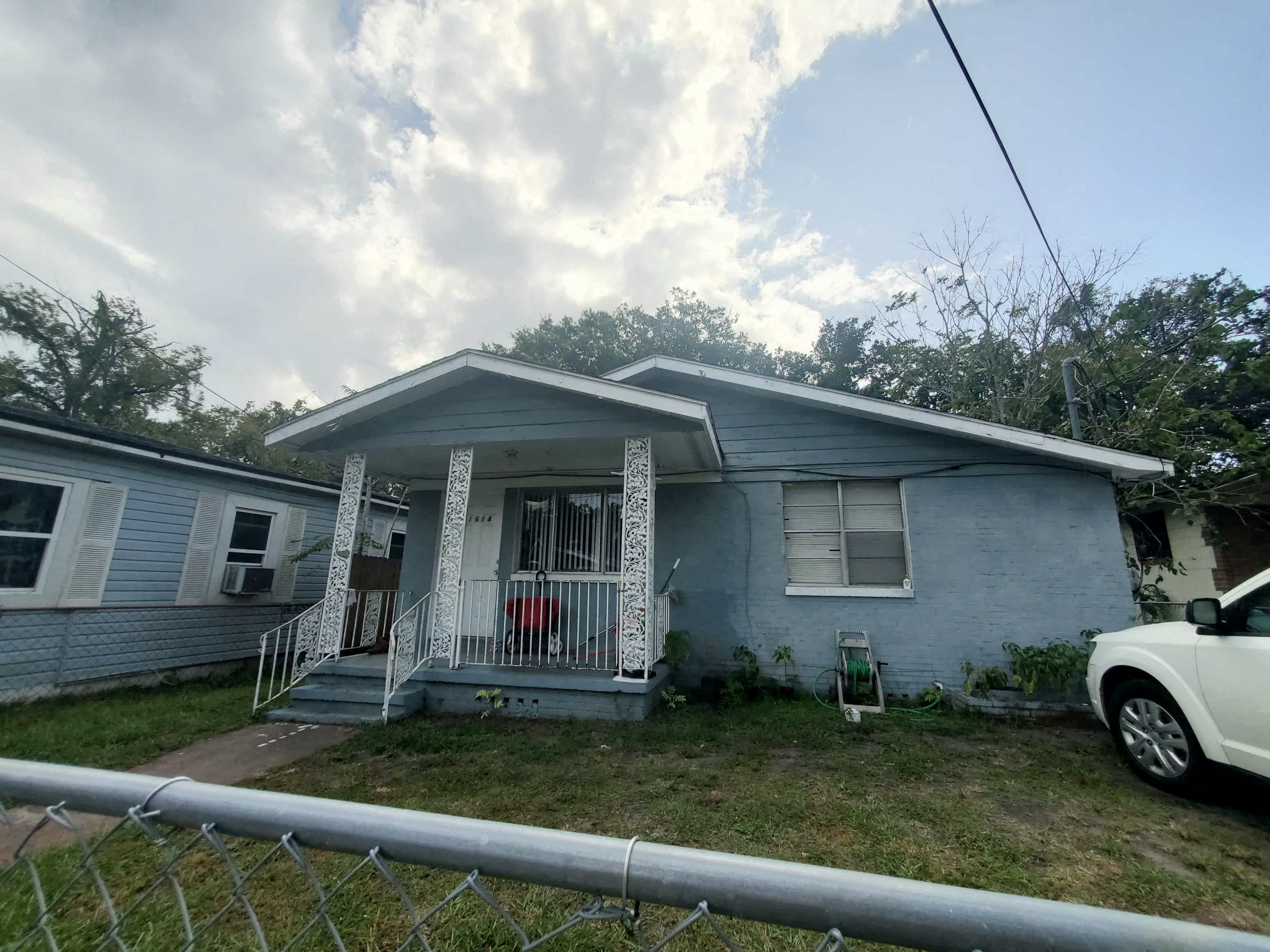 a blue house with a white car parked in front of it