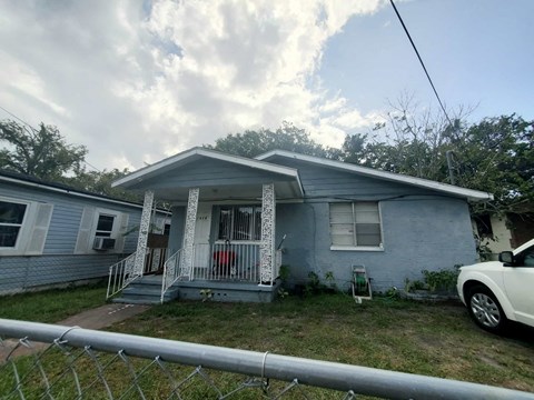 a blue house with a white car parked in front of it