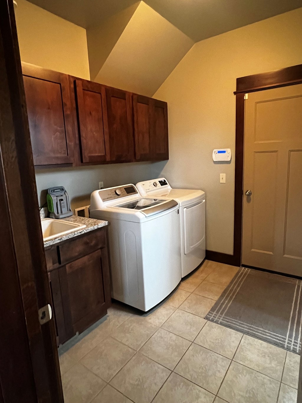 a laundry room with two washers and a sink and a door