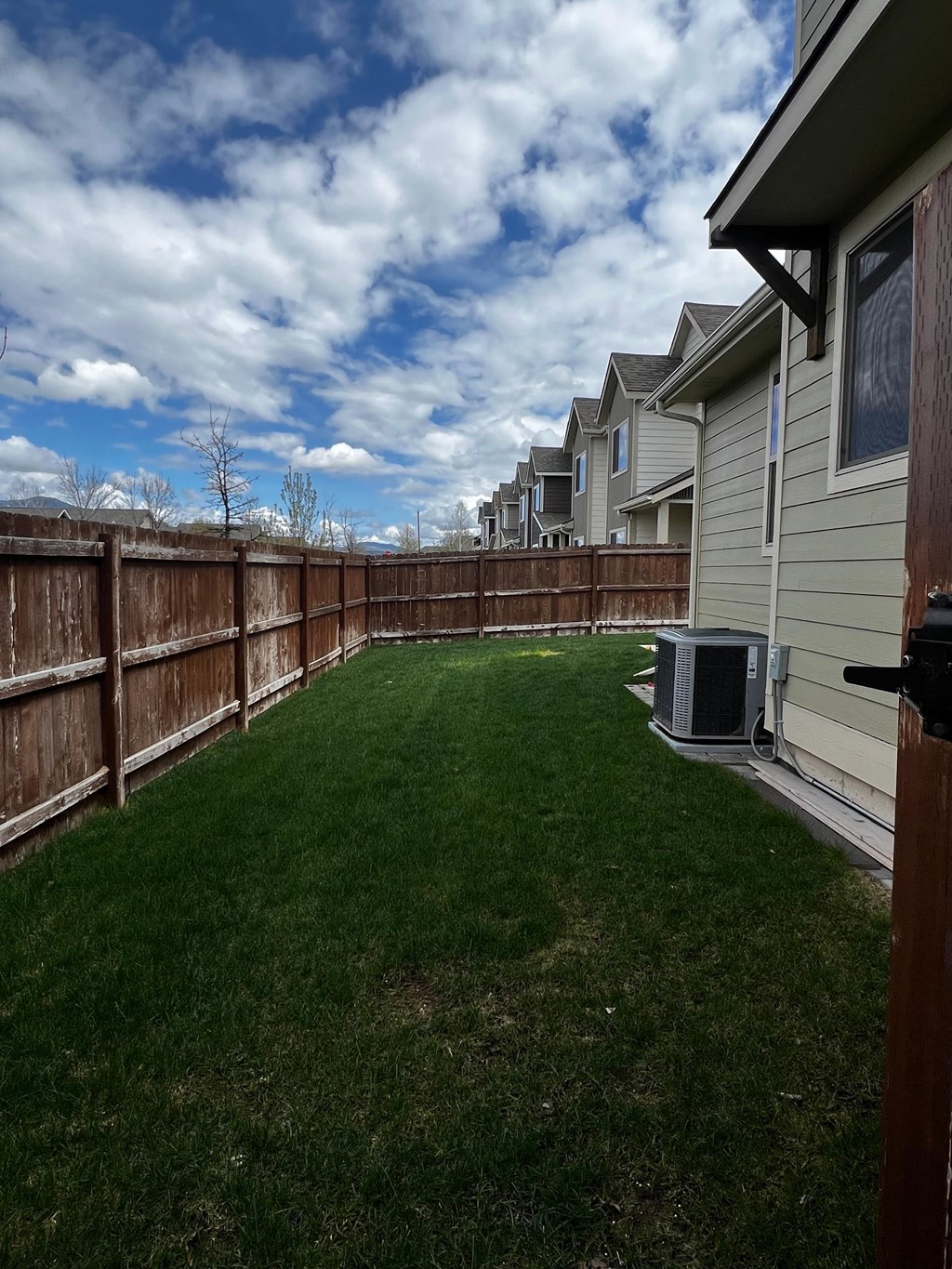 a backyard with a fence and a green lawn