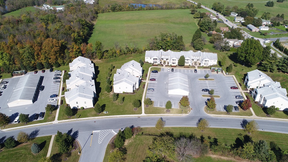 an aerial view of a neighborhood of houses and cars on a street