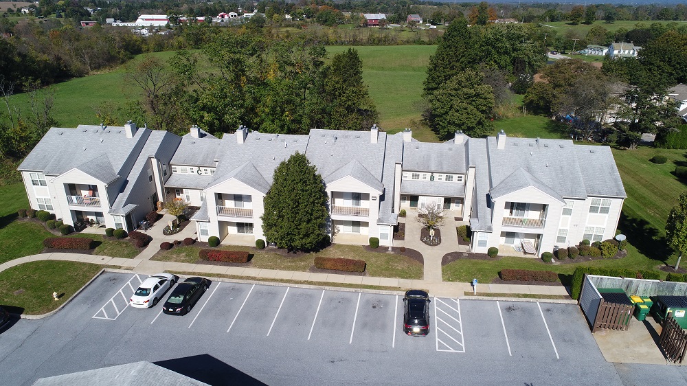 an aerial view of a large white house and parking lot