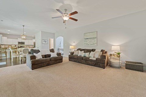 a living room with two couches and a ceiling fan