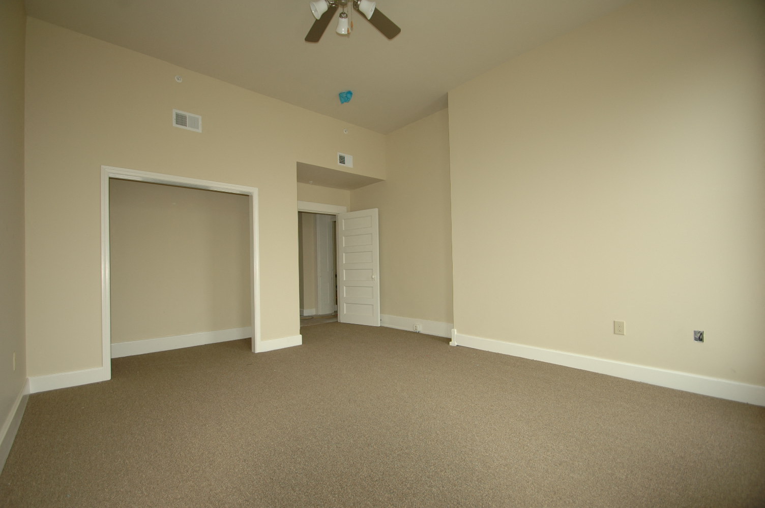 an empty living room with a ceiling fan