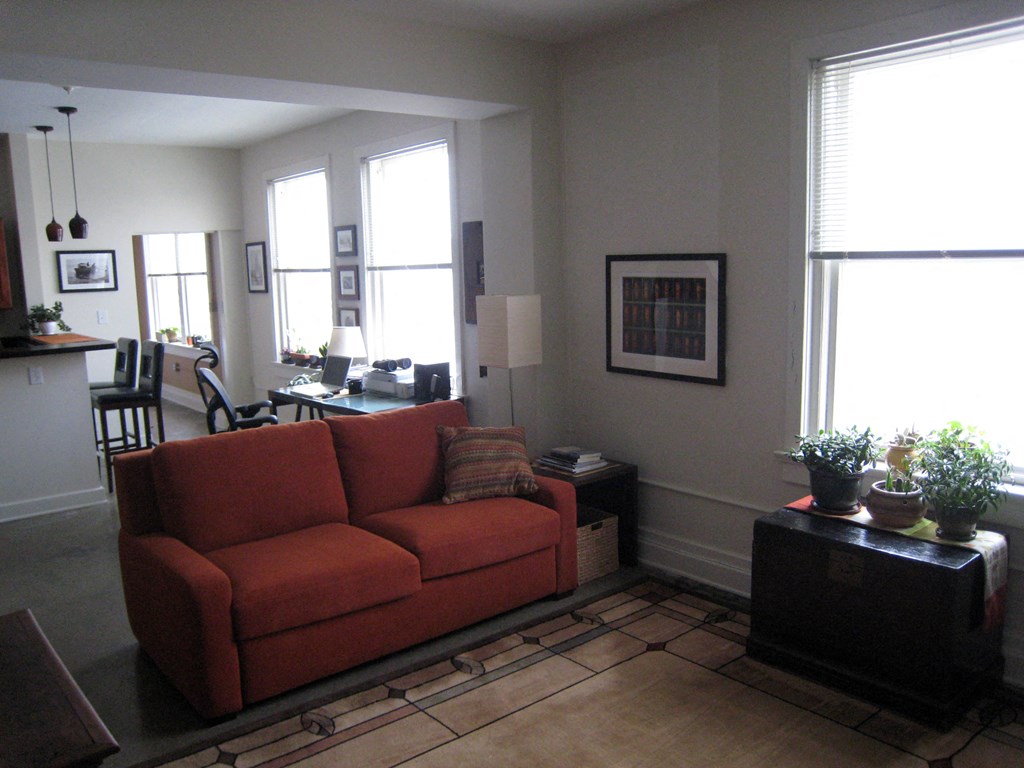 a living room with a red couch and a table
