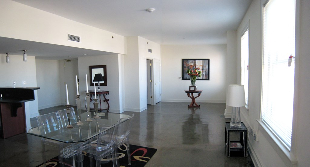a view of a living room with a glass table and chairs