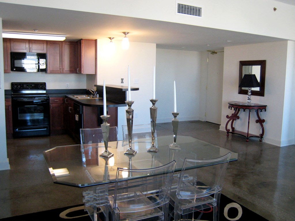 an open kitchen and dining room with a glass table and chairs