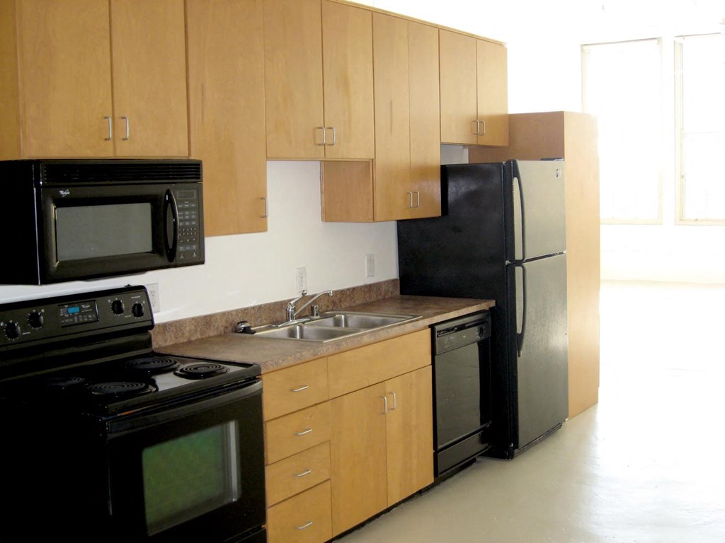 a kitchen with black appliances and wooden cabinets
