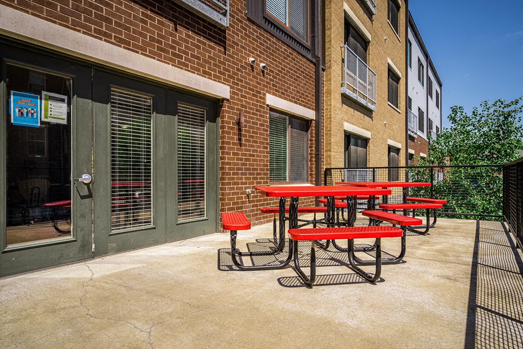 a patio with a table and chairs outside of a building