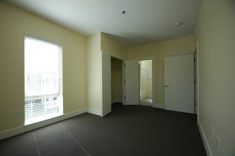 an empty living room with a window and a door