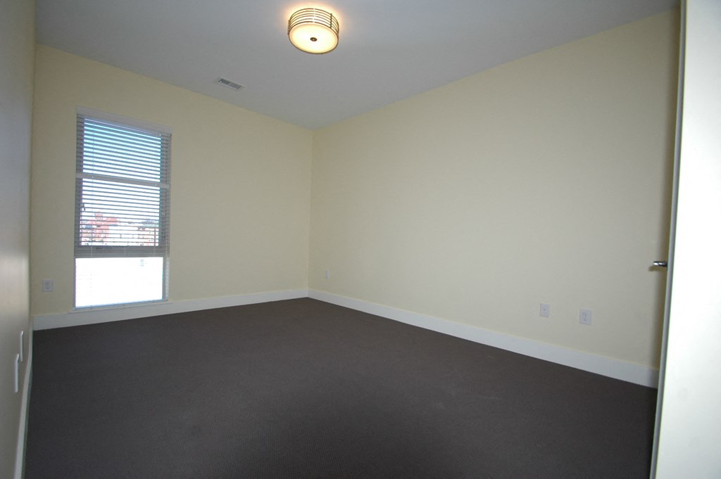 an empty living room with white walls and a window