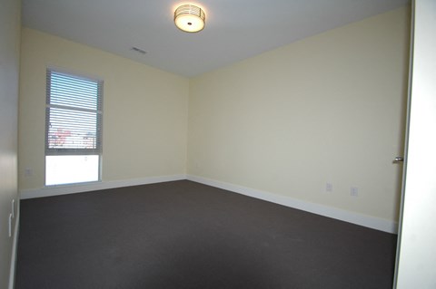 an empty living room with white walls and a window
