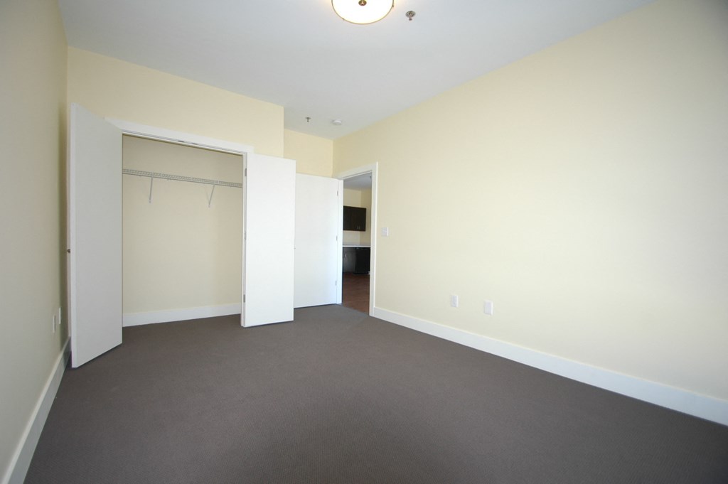 an empty living room with a door to a closet