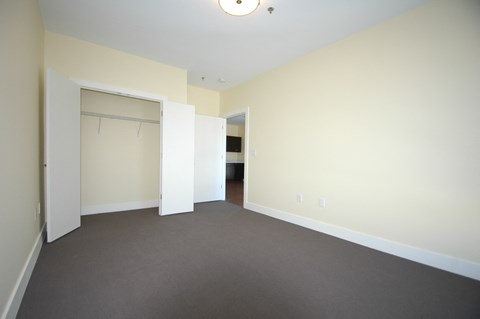 an empty living room with a door to a closet