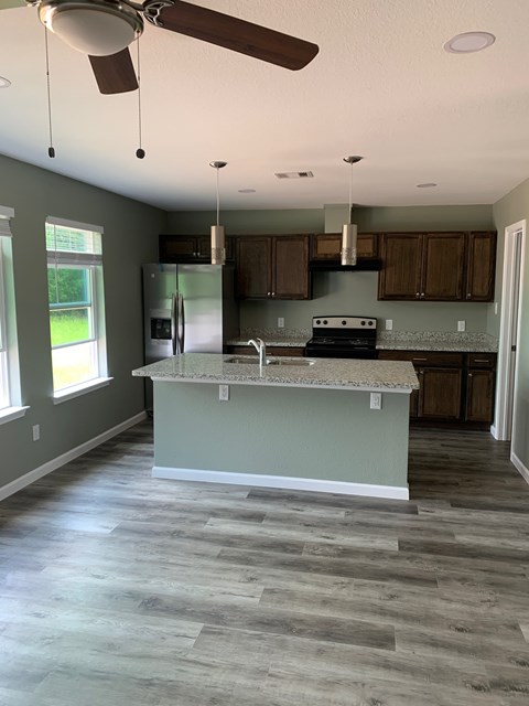 A kitchen with a countertop and a fan.