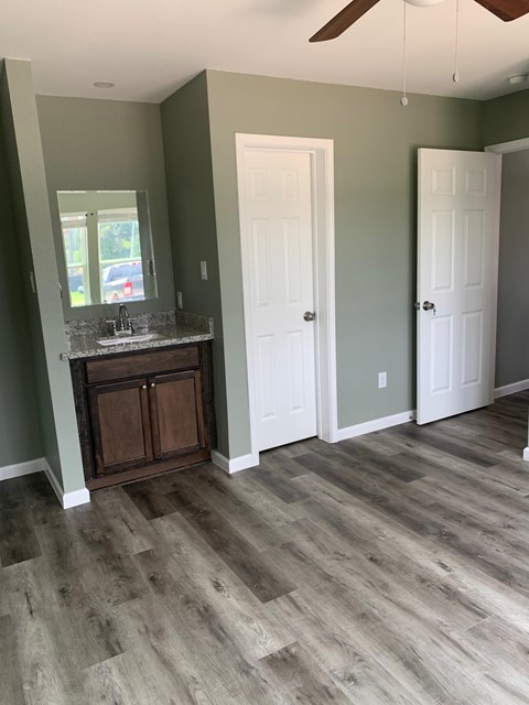 A room with a wooden floor and a ceiling fan.
