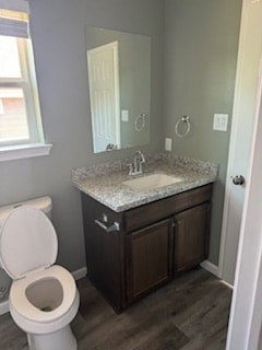 A bathroom with a toilet, sink and mirror.